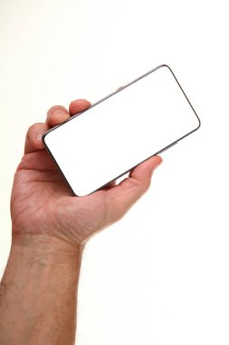 İnsan eli, avucunda boş bir krom ekran olan modern bir akıllı telefonu tutar. Teknoloji ve reklam kavramı. Ayrıntılı yakın çekim stüdyo çekimi soyut beyaz arka planda izole