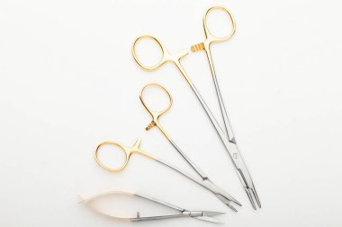 Çelik cerrahi aletler ve laboratuvar ekipmanları beyaz arka planda izole edilmiş. Profesyonel klinik aletleri. Tıbbi, cerrahi, ambulans ve veteriner konsepti. Yumuşak seçici odaklı yakın plan