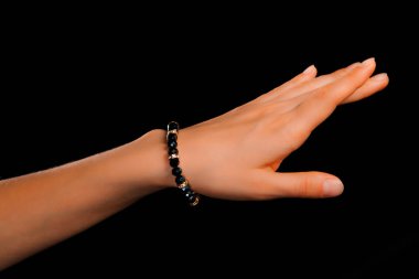 Güzel bir el yapımı mücevher bileziği. Renkli parlak boncuklar ve nötr manikürlü gevşek bir kadın bileği. Moda ve el işi aksesuarları. Yumuşak seçici odaklı yakın plan