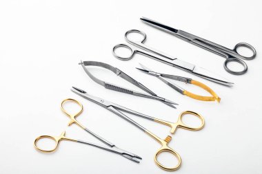 Çelik cerrahi aletler ve laboratuvar ekipmanları beyaz arka planda izole edilmiş. Profesyonel klinik aletleri. Tıbbi, cerrahi, ambulans ve veteriner konsepti. Yumuşak seçici odaklı yakın plan