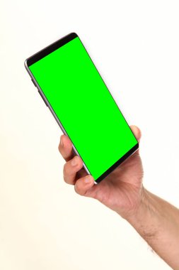 İnsan eli, avucunda boş bir krom ekran olan modern bir akıllı telefonu tutar. Teknoloji ve reklam kavramı. Ayrıntılı yakın çekim stüdyo çekimi soyut beyaz arka planda izole