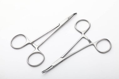 Çelik cerrahi aletler ve laboratuvar ekipmanları beyaz arka planda izole edilmiş. Profesyonel klinik aletleri. Tıbbi, cerrahi, ambulans ve veteriner konsepti. Yumuşak seçici odaklı yakın plan