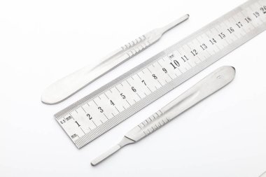 Çelik cerrahi aletler ve laboratuvar ekipmanları beyaz arka planda izole edilmiş. Profesyonel klinik aletleri. Tıbbi, cerrahi, ambulans ve veteriner konsepti. Yumuşak seçici odaklı yakın plan