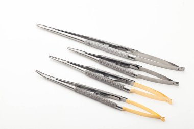 Çelik cerrahi aletler ve laboratuvar ekipmanları beyaz arka planda izole edilmiş. Profesyonel klinik aletleri. Tıbbi, cerrahi, ambulans ve veteriner konsepti. Yumuşak seçici odaklı yakın plan