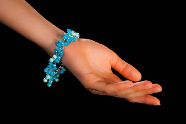 Güzel bir el yapımı mücevher bileziği. Renkli parlak boncuklar ve nötr manikürlü gevşek bir kadın bileği. Moda ve el işi aksesuarları. Yumuşak seçici odaklı yakın plan