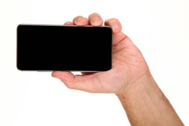 İnsan eli, avucunda boş bir krom ekran olan modern bir akıllı telefonu tutar. Teknoloji ve reklam kavramı. Ayrıntılı yakın çekim stüdyo çekimi soyut beyaz arka planda izole