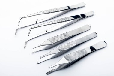 Çelik cerrahi aletler ve laboratuvar ekipmanları beyaz arka planda izole edilmiş. Profesyonel klinik aletleri. Tıbbi, cerrahi, ambulans ve veteriner konsepti. Yumuşak seçici odaklı yakın plan