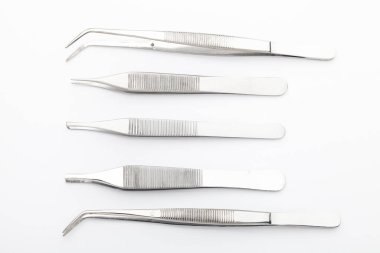 Çelik cerrahi aletler ve laboratuvar ekipmanları beyaz arka planda izole edilmiş. Profesyonel klinik aletleri. Tıbbi, cerrahi, ambulans ve veteriner konsepti. Yumuşak seçici odaklı yakın plan