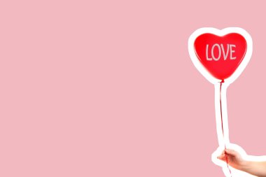 Kadın eli kırmızı kauçuk, şişme kalp şeklinde balon tutuyor. Aşk, ilişki, sevgililer günü ve doğum günü kutlaması konsepti. Boş kopya alanı olan dergi tarzı moda kolajı