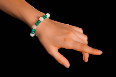 Güzel bir el yapımı mücevher bileziği. Renkli parlak boncuklar ve nötr manikürlü gevşek bir kadın bileği. Moda ve el işi aksesuarları. Yumuşak seçici odaklı yakın plan