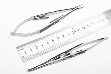 Çelik cerrahi aletler ve laboratuvar ekipmanları beyaz arka planda izole edilmiş. Profesyonel klinik aletleri. Tıbbi, cerrahi, ambulans ve veteriner konsepti. Yumuşak seçici odaklı yakın plan