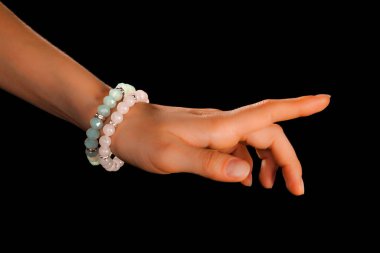 Güzel bir el yapımı mücevher bileziği. Renkli parlak boncuklar ve nötr manikürlü gevşek bir kadın bileği. Moda ve el işi aksesuarları. Yumuşak seçici odaklı yakın plan