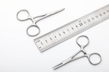 Çelik cerrahi aletler ve laboratuvar ekipmanları beyaz arka planda izole edilmiş. Profesyonel klinik aletleri. Tıbbi, cerrahi, ambulans ve veteriner konsepti. Yumuşak seçici odaklı yakın plan