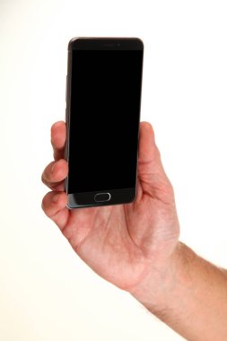 İnsan eli, avucunda boş bir krom ekran olan modern bir akıllı telefonu tutar. Teknoloji ve reklam kavramı. Ayrıntılı yakın çekim stüdyo çekimi soyut beyaz arka planda izole