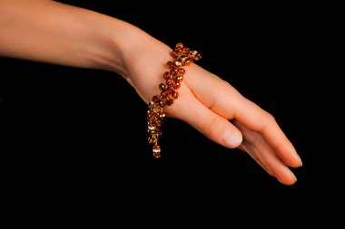 Güzel bir el yapımı mücevher bileziği. Renkli parlak boncuklar ve nötr manikürlü gevşek bir kadın bileği. Moda ve el işi aksesuarları. Yumuşak seçici odaklı yakın plan