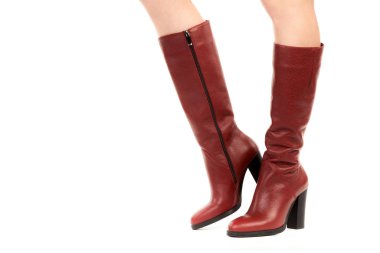 Bayan giysi ayakkabısı. Uzun ince dişinin bacakları yüksek topuklu uzun çizmeler giyer. Fotokopi alanı olan moda modeli. Klasik ve günlük kıyafet konsepti. Ayrıntılı yakın çekim stüdyo çekimi beyaz arkaplanda izole edildi