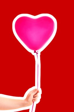 Kadın eli pembe kauçuk, şişme kalp şeklinde balon tutuyor. Aşk, ilişki, sevgililer günü ve doğum günü kutlaması konsepti. Boş kopya alanı olan dergi tarzı moda kolajı