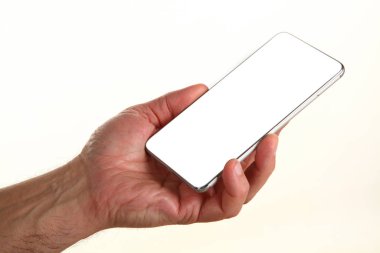 İnsan eli, avucunda boş bir krom ekran olan modern bir akıllı telefonu tutar. Teknoloji ve reklam kavramı. Ayrıntılı yakın çekim stüdyo çekimi soyut beyaz arka planda izole