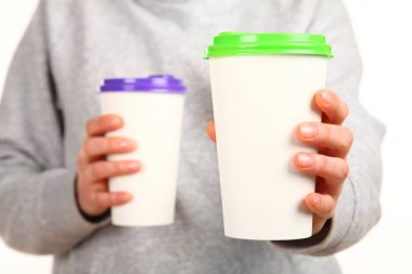 İnsan eli plastik kapaklı boş bir kahve fincanı tutar. Tek kullanımlık fincana çay ya da kahve konsepti. Metin veya logo için yeri ve yeri kopyala. Beyaz bir arkaplanda izole edilmiş