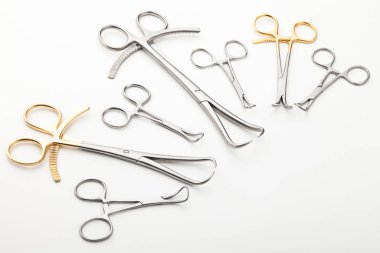 Çelik cerrahi aletler ve laboratuvar ekipmanları beyaz arka planda izole edilmiş. Profesyonel klinik aletleri. Tıbbi, cerrahi, ambulans ve veteriner konsepti. Yumuşak seçici odaklı yakın plan