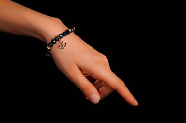 Güzel bir el yapımı mücevher bileziği. Renkli parlak boncuklar ve nötr manikürlü gevşek bir kadın bileği. Moda ve el işi aksesuarları. Yumuşak seçici odaklı yakın plan