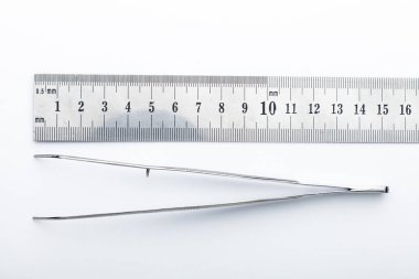 Çelik cerrahi aletler ve laboratuvar ekipmanları beyaz arka planda izole edilmiş. Profesyonel klinik aletleri. Tıbbi, cerrahi, ambulans ve veteriner konsepti. Yumuşak seçici odaklı yakın plan