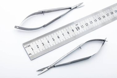 Çelik cerrahi aletler ve laboratuvar ekipmanları beyaz arka planda izole edilmiş. Profesyonel klinik aletleri. Tıbbi, cerrahi, ambulans ve veteriner konsepti. Yumuşak seçici odaklı yakın plan