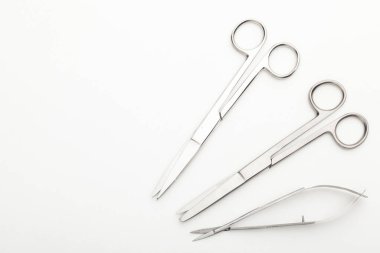 Çelik cerrahi aletler ve laboratuvar ekipmanları beyaz arka planda izole edilmiş. Profesyonel klinik aletleri. Tıbbi, cerrahi, ambulans ve veteriner konsepti. Yumuşak seçici odaklı yakın plan