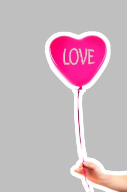 Kadın eli kırmızı kauçuk, şişme kalp şeklinde balon tutuyor. Aşk, ilişki, sevgililer günü ve doğum günü kutlaması konsepti. Boş kopya alanı olan dergi tarzı moda kolajı
