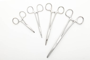 Çelik cerrahi aletler ve laboratuvar ekipmanları beyaz arka planda izole edilmiş. Profesyonel klinik aletleri. Tıbbi, cerrahi, ambulans ve veteriner konsepti. Yumuşak seçici odaklı yakın plan