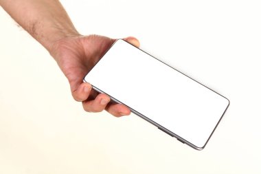 İnsan eli, avucunda boş bir krom ekran olan modern bir akıllı telefonu tutar. Teknoloji ve reklam kavramı. Ayrıntılı yakın çekim stüdyo çekimi soyut beyaz arka planda izole