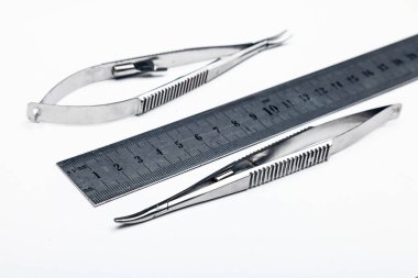 Çelik cerrahi aletler ve laboratuvar ekipmanları beyaz arka planda izole edilmiş. Profesyonel klinik aletleri. Tıbbi, cerrahi, ambulans ve veteriner konsepti. Yumuşak seçici odaklı yakın plan