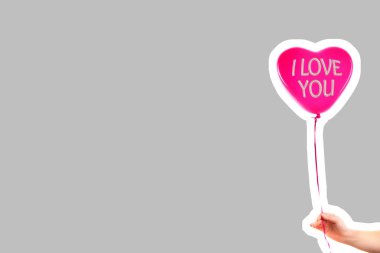 Kadın eli kırmızı kauçuk, şişme kalp şeklinde balon tutuyor. Aşk, ilişki, sevgililer günü ve doğum günü kutlaması konsepti. Boş kopya alanı olan dergi tarzı moda kolajı