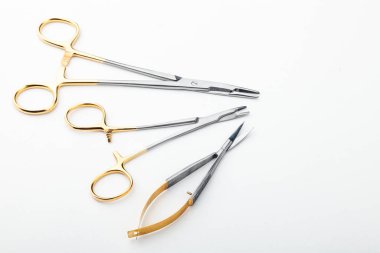 Çelik cerrahi aletler ve laboratuvar ekipmanları beyaz arka planda izole edilmiş. Profesyonel klinik aletleri. Tıbbi, cerrahi, ambulans ve veteriner konsepti. Yumuşak seçici odaklı yakın plan