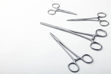 Çelik cerrahi aletler ve laboratuvar ekipmanları beyaz arka planda izole edilmiş. Profesyonel klinik aletleri. Tıbbi, cerrahi, ambulans ve veteriner konsepti. Yumuşak seçici odaklı yakın plan