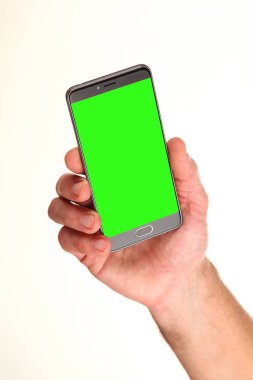 İnsan eli, avucunda boş bir krom ekran olan modern bir akıllı telefonu tutar. Teknoloji ve reklam kavramı. Ayrıntılı yakın çekim stüdyo çekimi soyut beyaz arka planda izole