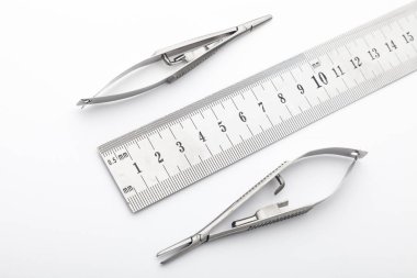 Çelik cerrahi aletler ve laboratuvar ekipmanları beyaz arka planda izole edilmiş. Profesyonel klinik aletleri. Tıbbi, cerrahi, ambulans ve veteriner konsepti. Yumuşak seçici odaklı yakın plan