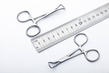 Çelik cerrahi aletler ve laboratuvar ekipmanları beyaz arka planda izole edilmiş. Profesyonel klinik aletleri. Tıbbi, cerrahi, ambulans ve veteriner konsepti. Yumuşak seçici odaklı yakın plan
