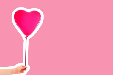 Kadın eli pembe kauçuk, şişme kalp şeklinde balon tutuyor. Aşk, ilişki, sevgililer günü ve doğum günü kutlaması konsepti. Boş kopya alanı olan dergi tarzı moda kolajı