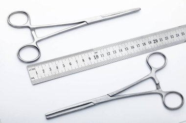 Çelik cerrahi aletler ve laboratuvar ekipmanları beyaz arka planda izole edilmiş. Profesyonel klinik aletleri. Tıbbi, cerrahi, ambulans ve veteriner konsepti. Yumuşak seçici odaklı yakın plan