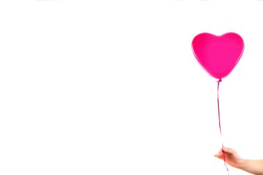 Kadın eli kırmızı kauçuk, şişme kalp şeklinde balon tutuyor. Aşk, ilişki, sevgililer günü ve doğum günü kutlaması konsepti. Stüdyo görüntüsü boş kopya alanı olan bulanık bir arkaplan üzerinde