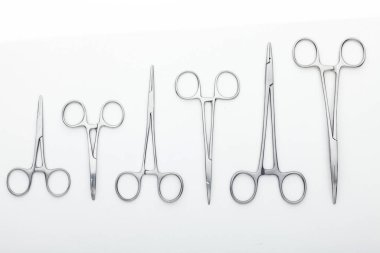 Çelik cerrahi aletler ve laboratuvar ekipmanları beyaz arka planda izole edilmiş. Profesyonel klinik aletleri. Tıbbi, cerrahi, ambulans ve veteriner konsepti. Yumuşak seçici odaklı yakın plan