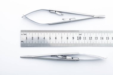 Çelik cerrahi aletler ve laboratuvar ekipmanları beyaz arka planda izole edilmiş. Profesyonel klinik aletleri. Tıbbi, cerrahi, ambulans ve veteriner konsepti. Yumuşak seçici odaklı yakın plan