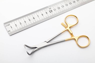 Çelik cerrahi aletler ve laboratuvar ekipmanları beyaz arka planda izole edilmiş. Profesyonel klinik aletleri. Tıbbi, cerrahi, ambulans ve veteriner konsepti. Yumuşak seçici odaklı yakın plan