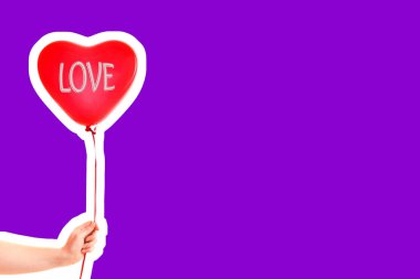 Kadın eli kırmızı kauçuk, şişme kalp şeklinde balon tutuyor. Aşk, ilişki, sevgililer günü ve doğum günü kutlaması konsepti. Boş kopya alanı olan dergi tarzı moda kolajı