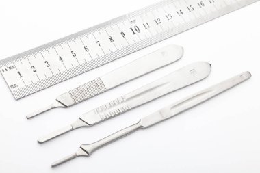 Çelik cerrahi aletler ve laboratuvar ekipmanları beyaz arka planda izole edilmiş. Profesyonel klinik aletleri. Tıbbi, cerrahi, ambulans ve veteriner konsepti. Yumuşak seçici odaklı yakın plan