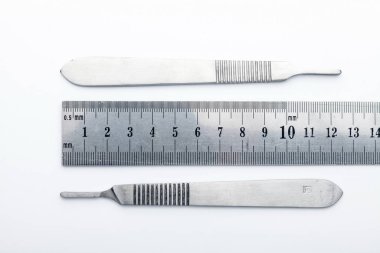 Çelik cerrahi aletler ve laboratuvar ekipmanları beyaz arka planda izole edilmiş. Profesyonel klinik aletleri. Tıbbi, cerrahi, ambulans ve veteriner konsepti. Yumuşak seçici odaklı yakın plan