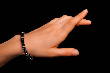 Güzel bir el yapımı mücevher bileziği. Renkli parlak boncuklar ve nötr manikürlü gevşek bir kadın bileği. Moda ve el işi aksesuarları. Yumuşak seçici odaklı yakın plan