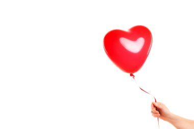Kadın eli kırmızı kauçuk, şişme kalp şeklinde balon tutuyor. Aşk, ilişki, sevgililer günü ve doğum günü kutlaması konsepti. Stüdyo görüntüsü boş kopya alanı olan bulanık bir arkaplan üzerinde