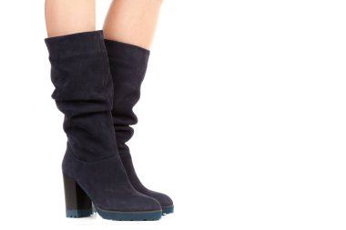 Bayan giysi ayakkabısı. Uzun ince dişinin bacakları yüksek topuklu uzun çizmeler giyer. Fotokopi alanı olan moda modeli. Klasik ve günlük kıyafet konsepti. Ayrıntılı yakın çekim stüdyo çekimi beyaz arkaplanda izole edildi